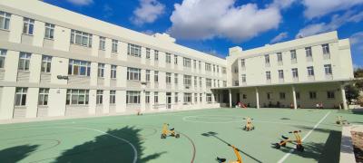 Widok przedstawiający szkołę wraz z szkolnym boiskiem.