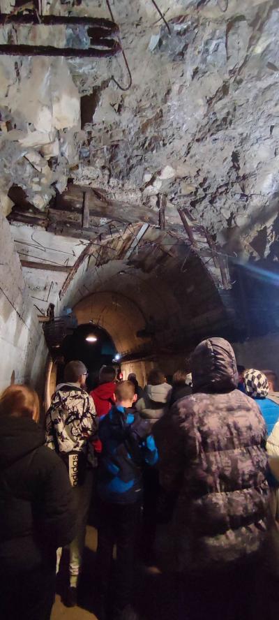 Uczniowie poznają historię wydrążenia tunelu w podziemiach.