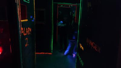 Pomieszczenie gdzie rozgrywa się LaserShot z fluorescencyjnymi krawędziami i napisami.