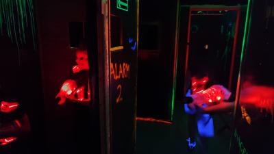 Pomieszczenie gdzie rozgrywa się LaserShot z fluorescencyjnymi krawędziami i napisami.