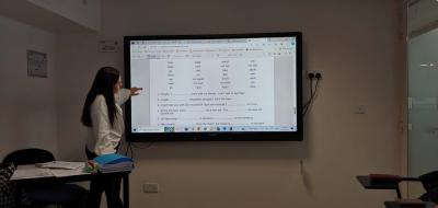 Lektor języka angielskiego w czasie prezentacji materiału na tablicy interaktywnej.