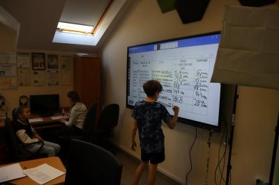 Uczeń wykonuje obliczenia na monitorze interaktywnym