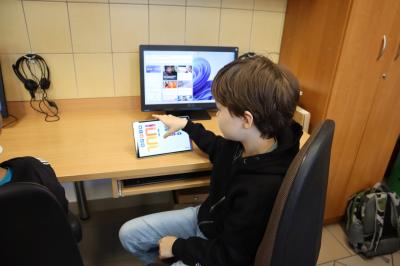 Uczniowie programują robota z użyciem tableta.