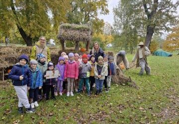 Grupa przedszkolaków stoi przed farmą dyni Grupa przedszkolaków stoi przed farmą dyni
