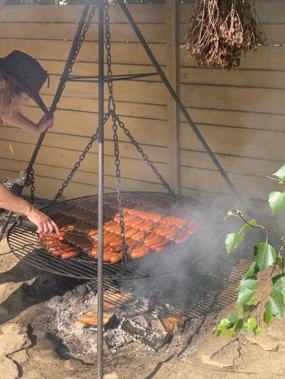 Na dużym trójnożnym grilu pieką się kiełbaski (1).jpg