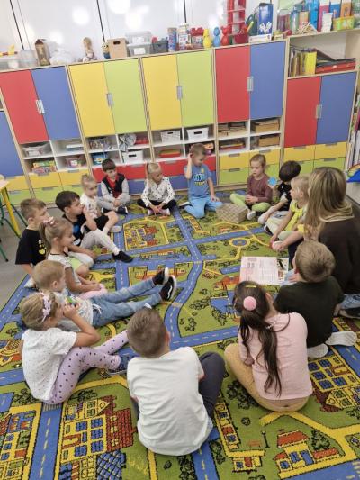 Dzieci siedzą na dywanie i rozmawiają.jpg