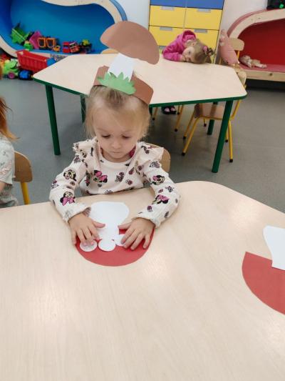 Dziewczynka z grupy krasnale układa na grzybie kropki.jpg