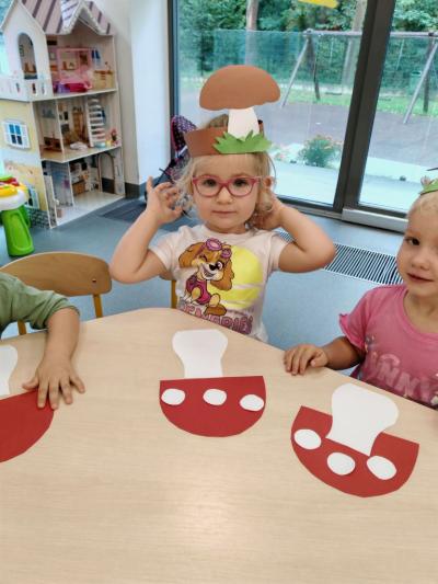 Dziewczynki z grupy krasnali prezentują swoją pracę plastyczną, Na głowie maja opaski grzyba..jpg
