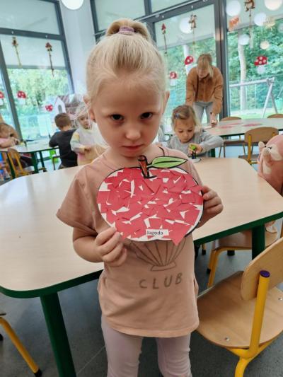 Dziewczynka pokazuje pracę plastyczną. (2).jpg