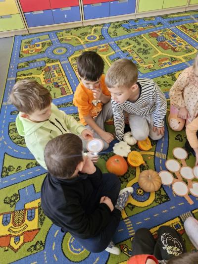 Chłopcy oglądają produkty z dyni za pomocą latarki.jpg