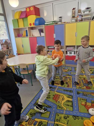 Chłopcy stoją w kole i podają sobie dynie (2).jpg