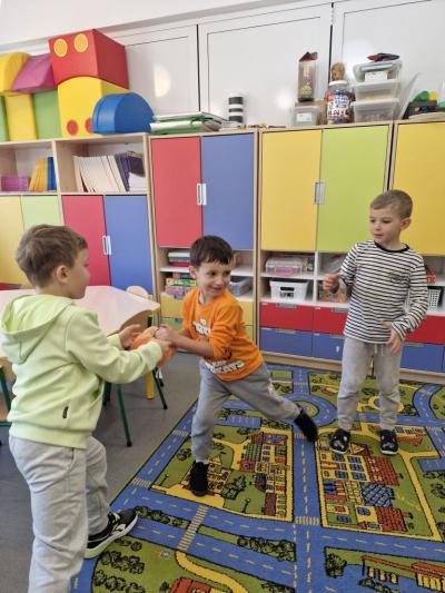 Chłopcy stoją w kole i podają sobie dynie.jpg