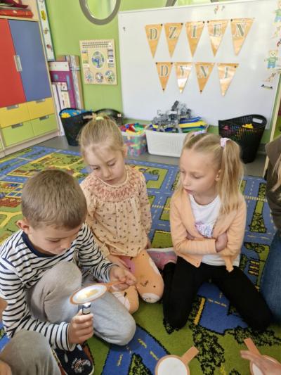 Dzieci oglądają produkty z dyni za pomocą latarki.jpg