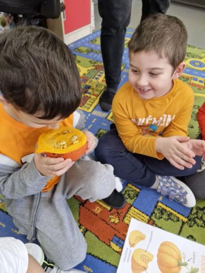 Dzieci siedzą na dywanie i oglądają wnętrze dyni (3).jpg