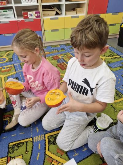 Dzieci siedzą na dywanie i oglądają wnętrze dyni (4).jpg