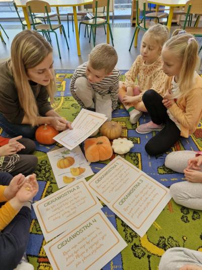 Dzieci siedzą na dywanie i słuchają ciekawostek o dyni (3).jpg