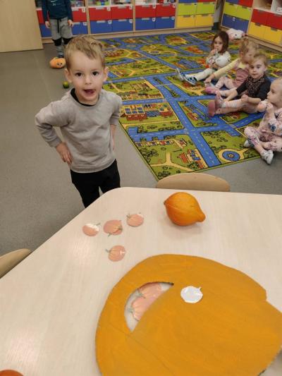 Chłopczyk celuje do buzi dyni.jpg