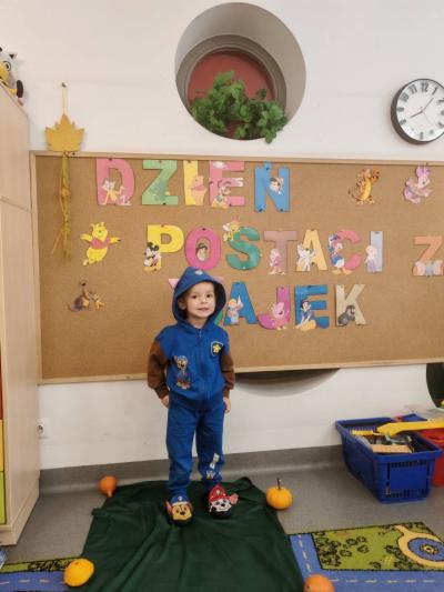 Chłopczyk pozuje na tle tablicy.jpg