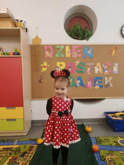 Dziewczynka pozuje na tle tablicy.jpg