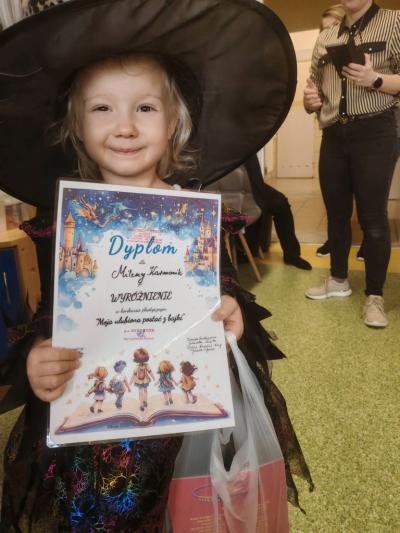 Dziewczynka pozuje z dyplomem.jpg