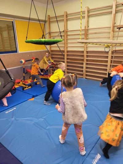 Dzieci ćwiczą lub  bawią się w sali ćwiczeń..JPG