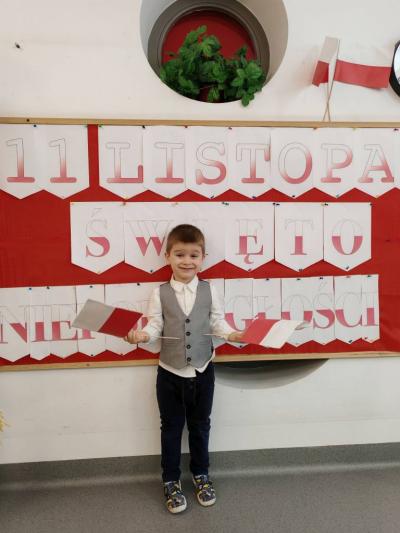 Chłopczyk na tle tablicy  pozuje do zdjecia.jpg