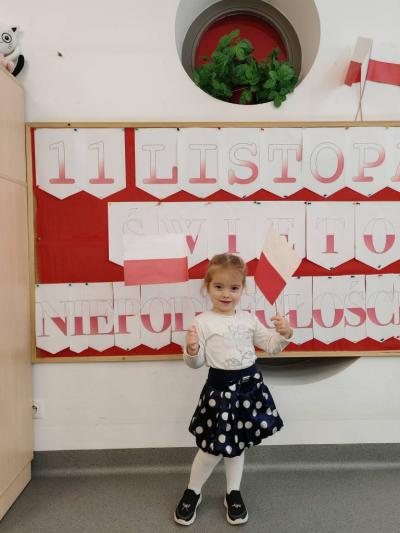 Dziewczynka na tle tablicy pozuje do zdjęcia (2).jpg