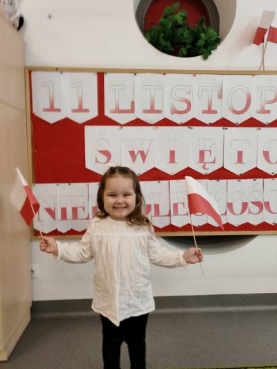 Dziewczynka na tle tablicy pozuje do zdjecia (3).jpg