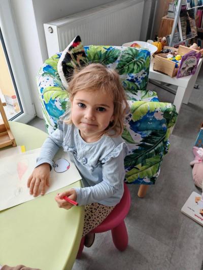 Dziewczynka siedzi przy stoliku.jpg