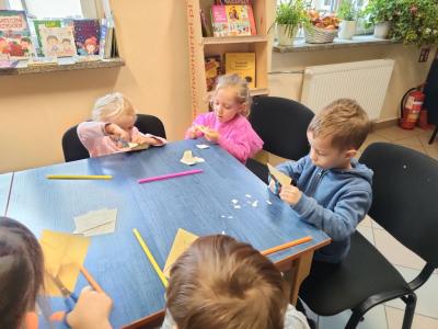 Dwie dziewczynki i chłopiec wycinają przy stoliku..jpg