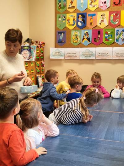 Pani bibliotekarka z dziećmi przy stoliku..jpg