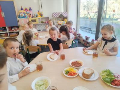 Dwie dziewczynki i chłopiec robią kanapki. W tle inny stolik..jpg