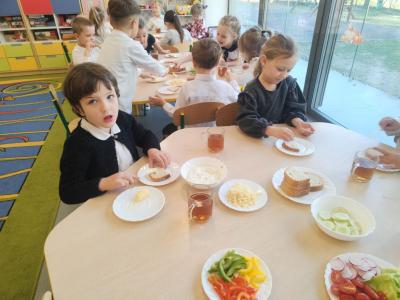 Dwie dziewczynki robią kanapki przy stoliku. Wtle inne stoliki..jpg