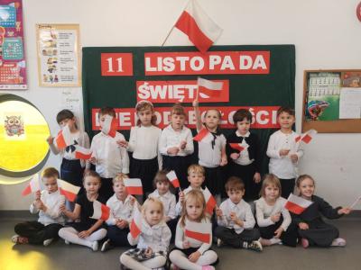 Zdjęcie grupowe dzieci z grupy Sówki. Dzieci trzymają flagi..jpg