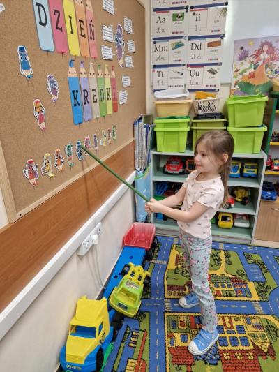 Dziewczynka wskazuje kredkę, zgodnie ze wskazówką.jpg