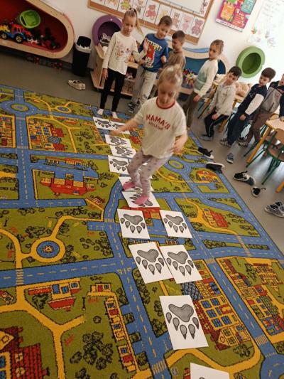 dzieci skaczą po śladach misia.jpg