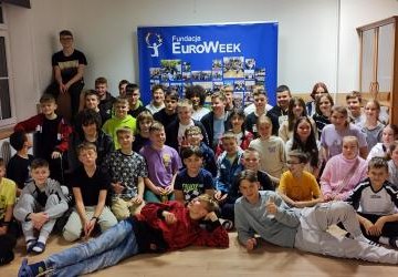 Grupowe zdjęcie wszystkich uczestników projektu na tle plakatu EuroWeek.