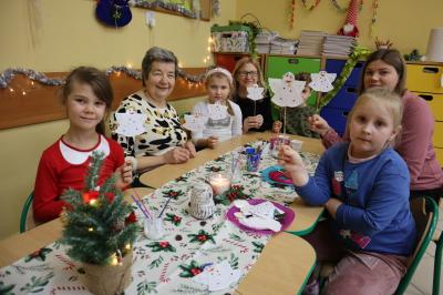 Dzieci z przedszkola wraz z zaproszonymi seniorami wykonują ozdoby świąteczne.