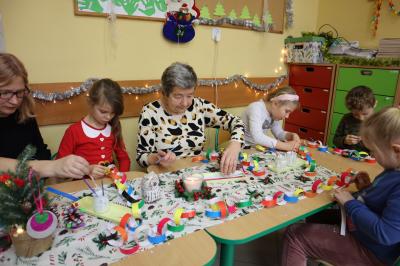 Dzieci z przedszkola wraz z zaproszonymi seniorami wykonują ozdoby świąteczne.