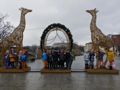 Dzieci pod pomnikiem z żyrafami