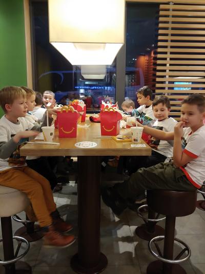 Dzieci siedzą przy stolikach w McDonalds