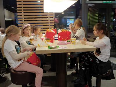 Dzieci siedzą przy stolikach w McDonalds