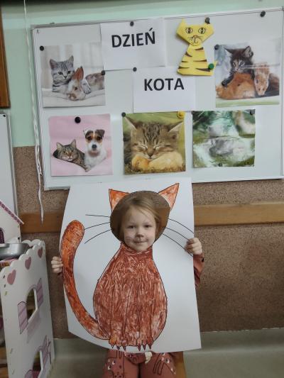 Dziewczynka w fotobudce z wizerunkiem kota.