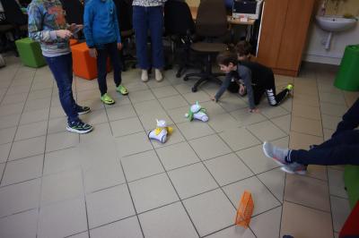 Uczniowie za pomocą robotów Photon rozgrywają mecz piłki nożnej,