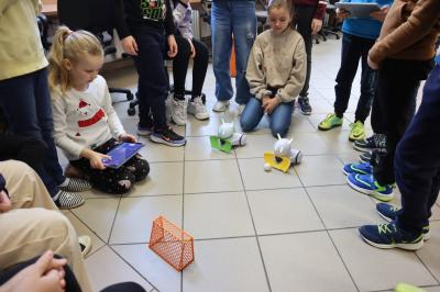 Uczniowie za pomocą robotów Photon rozgrywają mecz piłki nożnej,