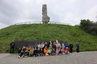 Dzieci uczestniczące w wycieczce zwiedzają  pomnik przy Westerplatte.