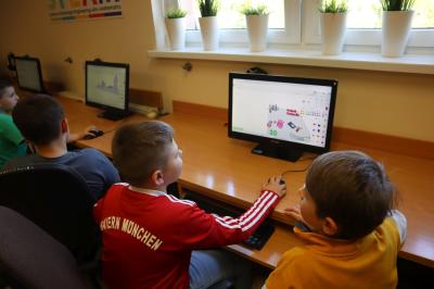 Uczniowie szkoły podstawowej biorący udział w warsztatach modelowania 3D na platformie Tinkercad. Uczestnicy spotkania pracuja w przestrzeni 3D przy komputerach/