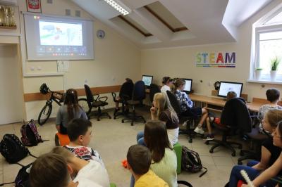 Uczniowie szkoły podstawowej biorący udział w warsztatach modelowania 3D na platformie Tinkercad. Uczestnicy spotkania pracuja w przestrzeni 3D przy komputerach
