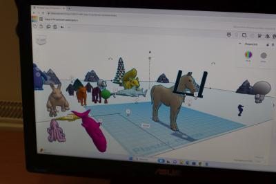 Uczniowie szkoły podstawowej biorący udział w warsztatach modelowania 3D na platformie Tinkercad. Ekran monitora na którym widac platformę projektowania Tinkercad.