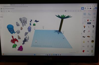 Uczniowie szkoły podstawowej biorący udział w warsztatach modelowania 3D na platformie Tinkercad. Ekran monitora na którym widac platformę projektowania Tinkercad.